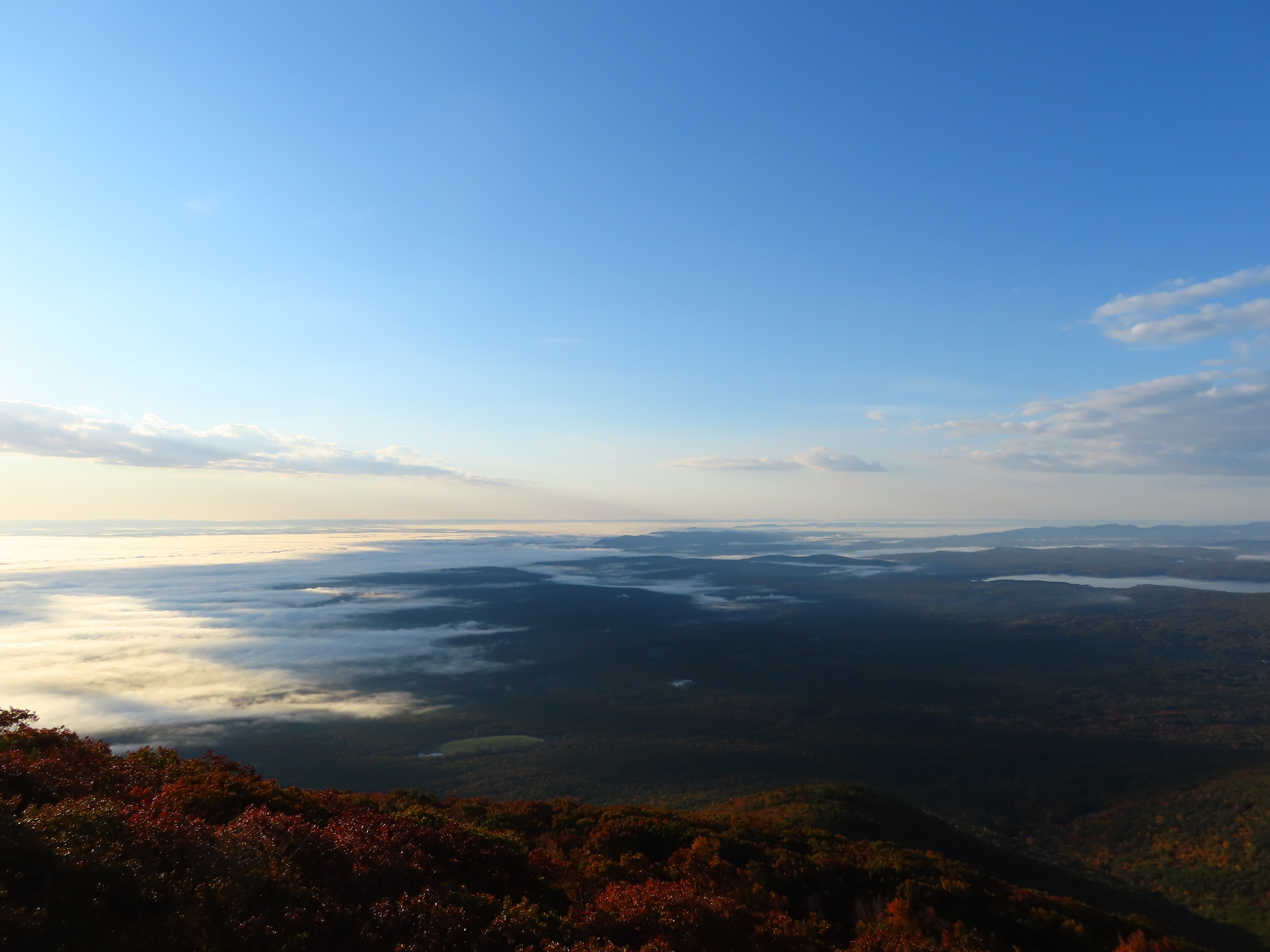 Sunrise at mountain summit with mist and fall foliage
